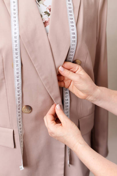 istock Seamstress straightens collar on beige jacket 1400569930
