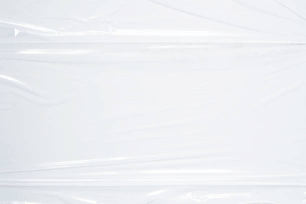 istock Transparent plastic wrap on white color background. Crumpled wrinkled plastic cellophane. Reflecting light and shadow on creases and folds in plastic surface. Texture overlay effect template 1400570313