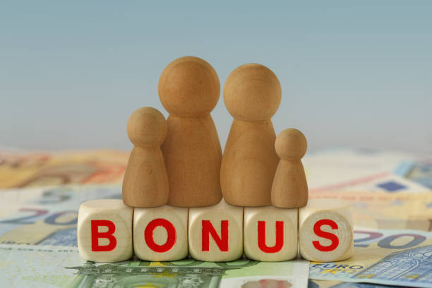 Family on wooden blocks with the word Bonus on euro banknotes - Concept of economic bonus and financial aid stock photo