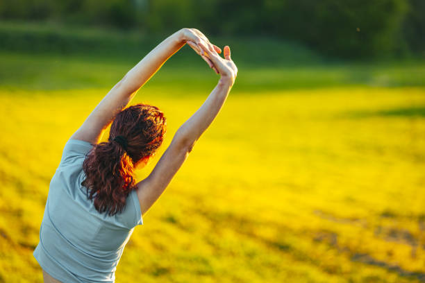 Young female runner warming up before running at morning forest