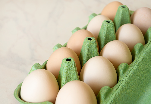 chicken eggs in green eco cardboard egg tray.