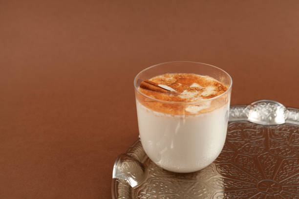 istock Salep or Sahlep in glass on brown background. Selective focus, copy space. Salep - Turkish instantly drink with cinnamon 1400577200