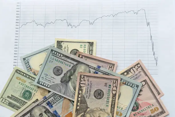 Photo of American dollar banknotes with decrease diagram trend