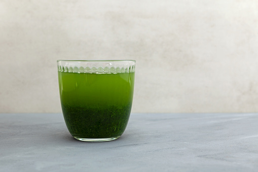 With long green ice tea and glass teapot on unfocused background