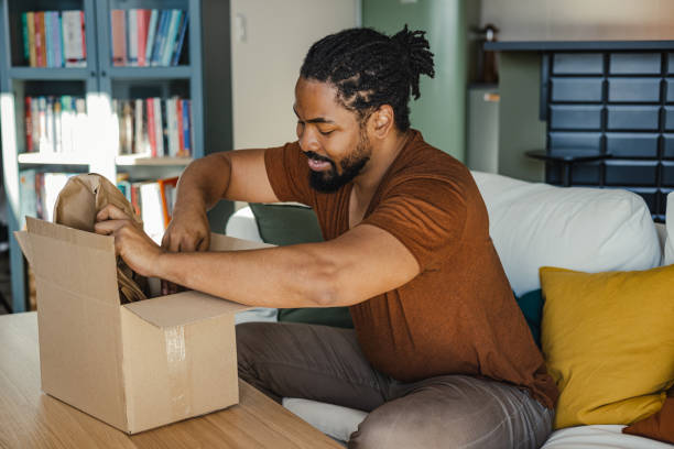istock Young man unpacking the box in which his online order has arrived 1400583208