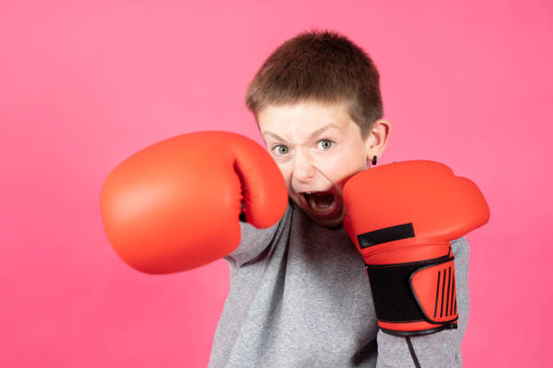istock Aggressive boy punching at camera isolated on pink background 1400584456