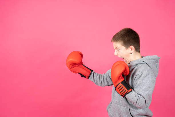 visão lateral de adolescente usando luvas de boxe - shirt problems red pink - fotografias e filmes do acervo