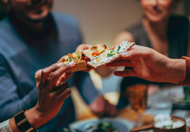 Unrecognizable Friends Toasting With Appetizer During A Dinner Celebration