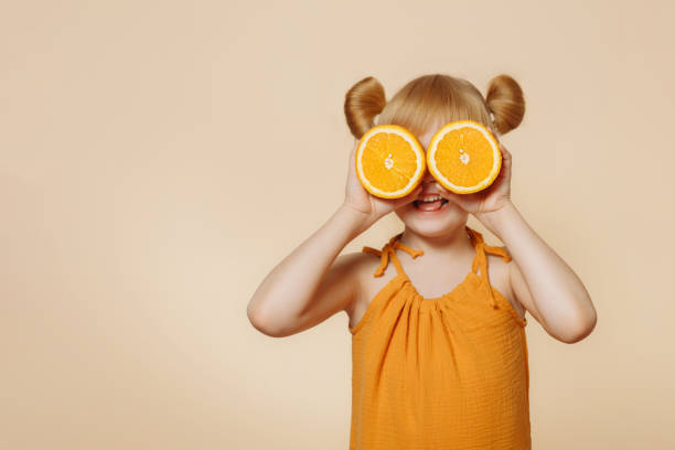 istock Girl holding oranges in front of her face 1400587237