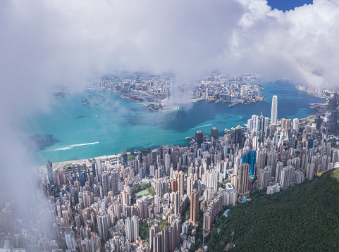Epic aerial view of the Victoria Harbour in a clear day, with thick cloud and sunlight, Hong Kong