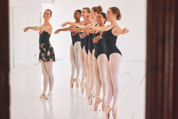 istock Young woman dance instructor teaching a ballet class to a group of a children in her studio. Ballerina teacher working with girl students, preparing for their recital, performance or upcoming show 1400591623