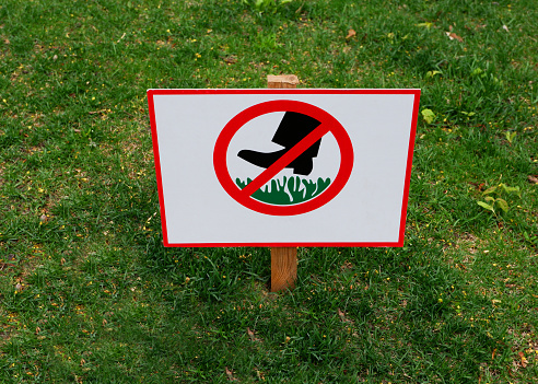 A sign prohibiting walking on the lawn.