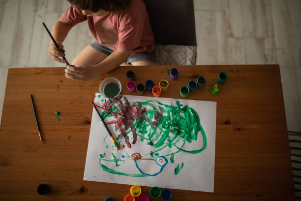istock Unrecognizable child painting at the desk 1400596902