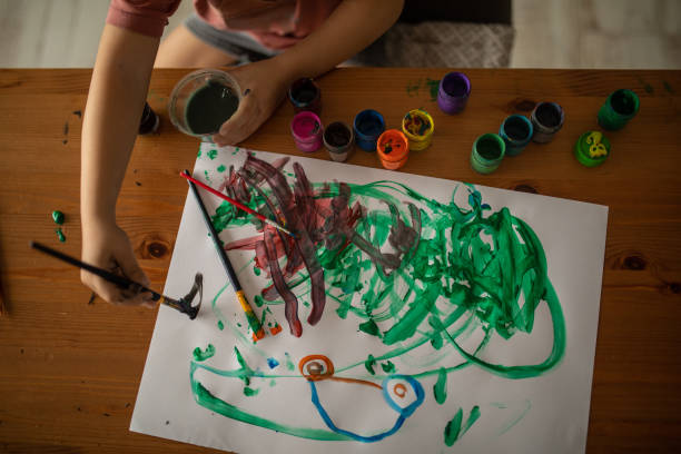 istock Unrecognizable child painting at the desk 1400598387