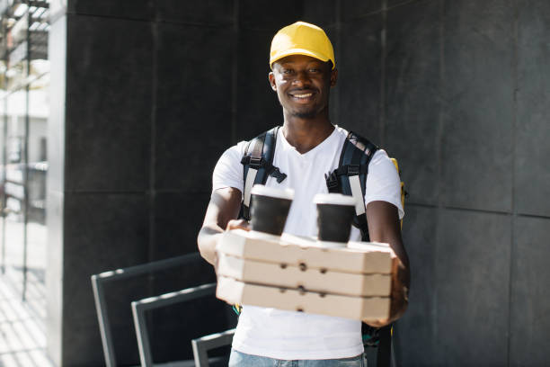 istock African courier delivering boxes with pizza and hot coffee. 1400598601