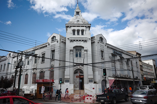 Osorno, Chile - February, 2020: Building with grey facade built in 1927 in Art Deco architectural style on corner of Eleuterio Ramirez street in old town. Sidewalk repair in historic city center