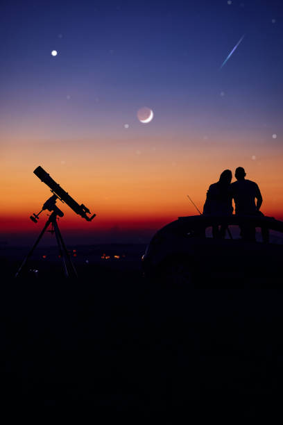 istock Couple stargazing together with a astronomical telescope. 1400599754