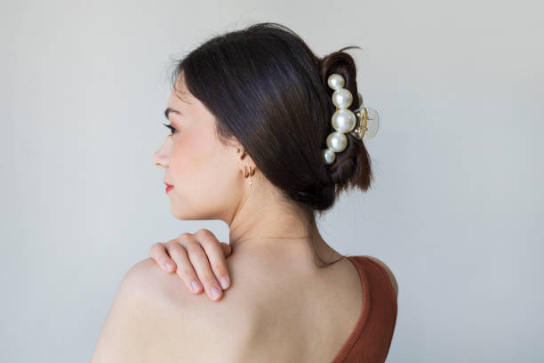 giovane donna con belle clip per capelli su sfondo grigio - jewelry fashion model women personal accessory foto e immagini stock