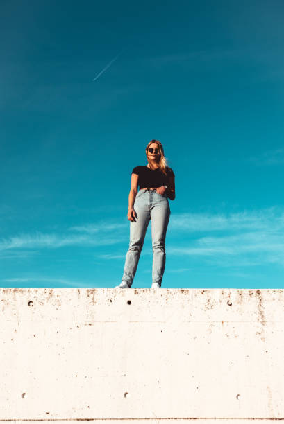 istock Young Woman Standing on Concrete Wall 1400605707