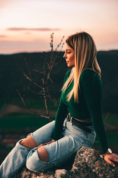 istock Confident Young Woman Sitting Outdoors in Sunset Light Portrait 1400606604