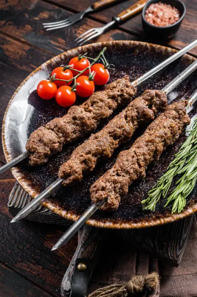 Grilled Shish kebab on skewers from minced lamb beef meat, Lula kebab. Wooden background. Top view.