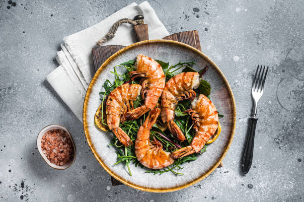 ensalada con gambas gigantes a la plancha en plato. fondo gris. vista superior - grilled shrimp fotos fotografías e imágenes de stock