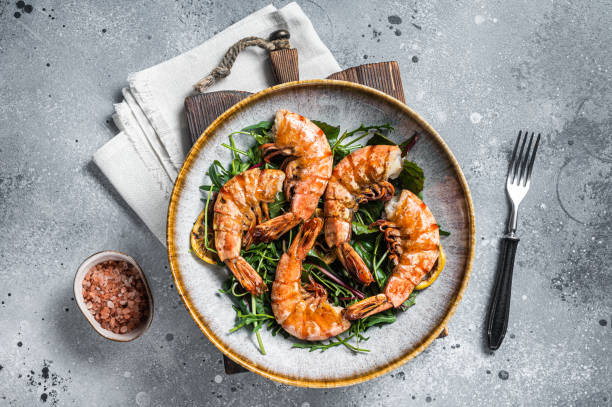 insalata con gamberi giganti grigliati in piatto. sfondo grigio. vista dall'alto - grilled shrimp foto e immagini stock