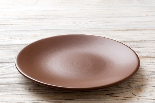 Perspective view of empty plate on wooden background. Empty space for your design.