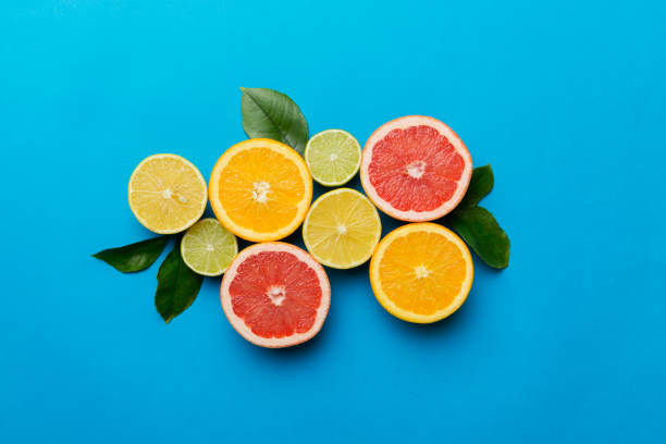 istock Fruit background. Colorful fresh fruits on colored table. Orange, lemon, grapefruit Space for text healthy concept. Flat lay, top view, copy space 1400611694
