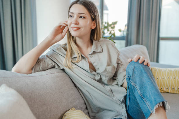 istock Front view of a young woman sitting on sofa 1400611770