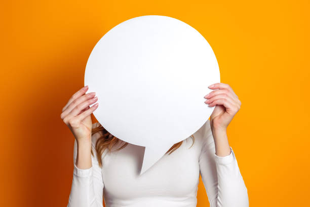 istock Student hold blank white speech balloon isolated on an orange studio background. copy space 1400612092