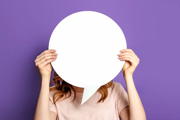 istock Student with blank white speech bubble isolated on purple studio background. copy space. woman holding a round information piece of paper dialog. 1400612098
