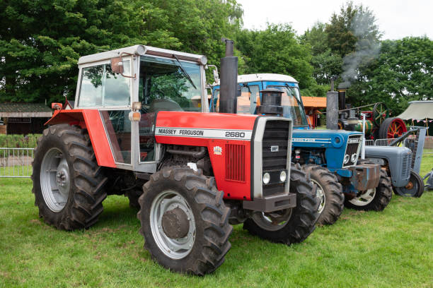 Staffordshire, England, UK - A Massey Ferguson 2680 Tractor built between 1981-1985, a blue Ford County 6600 Four can be seen alongside.