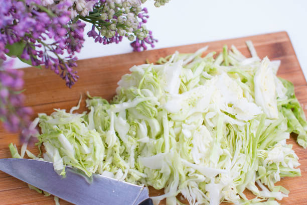 Sliced white cabbage. Slicing vegetables on a wooden board Sliced white cabbage. Slicing vegetables on a wooden board white cabbage stock pictures, royalty-free photos & images