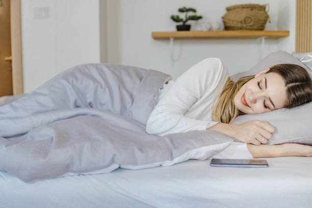 istock Young woman sleeping in bed at home 1400613197