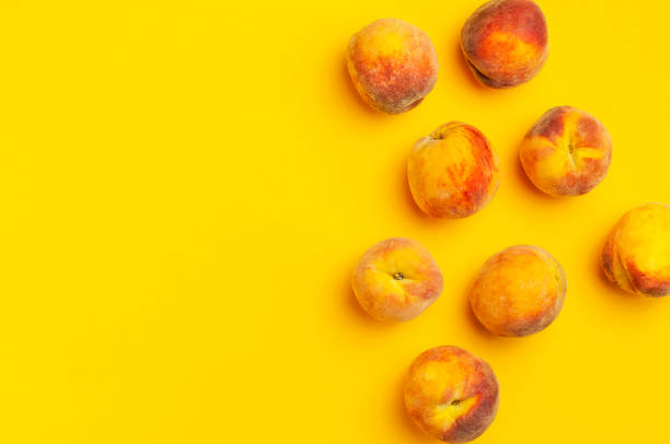 istock Summer fruit background. Flat lay composition with peaches. Ripe juicy peaches with green leaves on yellow background. Flat lay top view copy space. Fresh organic fruit, vegan food. Harvest concept 1400614693