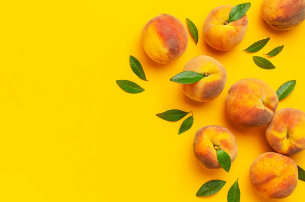 istock Summer fruit background. Flat lay composition with peaches. Ripe juicy peaches with green leaves on yellow background. Flat lay top view copy space. Fresh organic fruit, vegan food. Harvest concept 1400614751