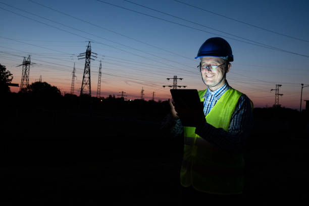 istock Portrait of cheerful male technician using a digital tablet in front of electric power station 1400617708