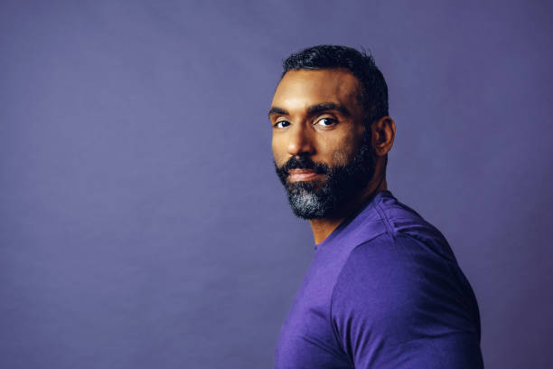 紫色の背景にひげと口ひげを持つハンサムなひげを生やした男性の肖像画 - mature adult men male african descent ストックフォトと画像