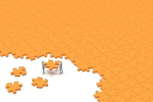 Business team putting the puzzle pieces in place, 3D - Computer generated image