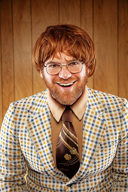 A confused nerdy guy looks up with a confused look on his face, with glasses and squinty eyes. He also has a fake gold tooth in his mouth.