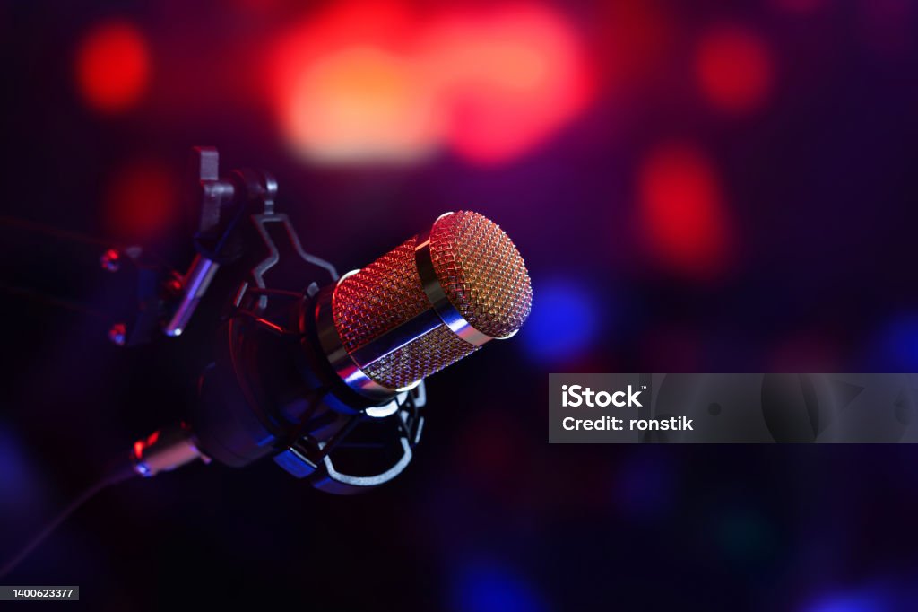 studio microphone in neon lights. sound recording equipment Podcasting Stock Photo