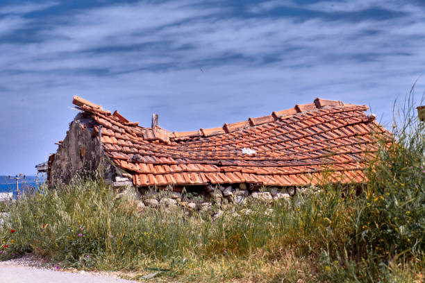 View of a countryside house with damaged roof.