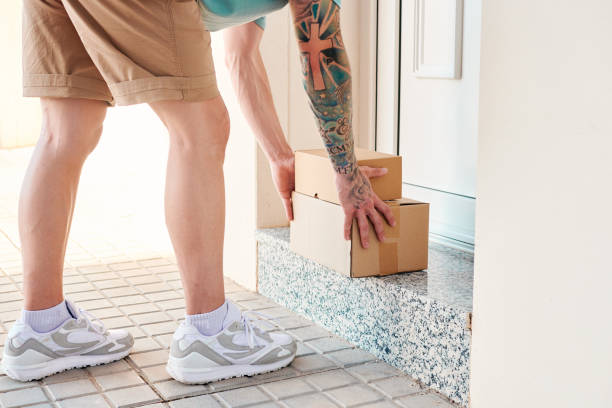 istock Letter carrier leaves boxes in front of a door 1400627229