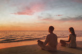 mindfulness, couple doing yoga and breathing exercises at sunset