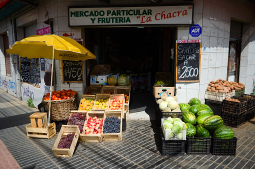 Osorno, Chile - February, 2020: Outside stall of small grocery store with vegetables and fruits. Street counter with fresh fruits and vegetables such as watermelons, grapes, tomatoes, peaches, melons