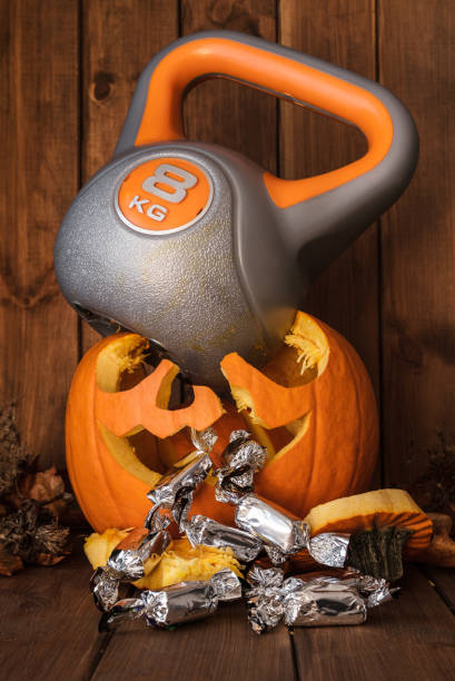 istock Heavy kettlebell crushing carved Halloween pumpkin. 1400632336