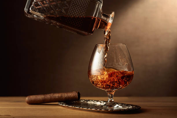 cognac und zigarre auf einem eichentisch. - wine decanter elegance pouring stock-fotos und bilder