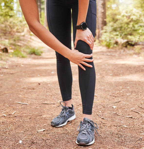 Close up of an athletic young woman holding her knee in pain while exercising outdoors. Active woman wearing running shoes and suffering an unfortunate joint injury while out for a workout in nature primer plano de una joven atlética sosteniendo su rodilla con dolor mientras hace ejercicio al aire libre. mujer activa que usa zapatos para correr y sufre una desafortunada lesión en las articulaciones mientras realiza un entrenamiento en la naturaleza