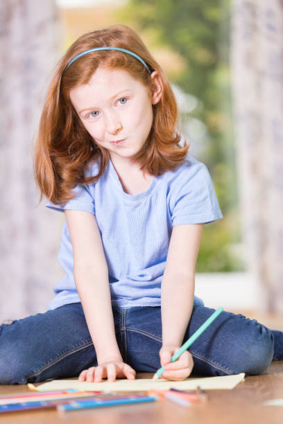 Cute teenage girl in casual stylish clothes sitting against white background